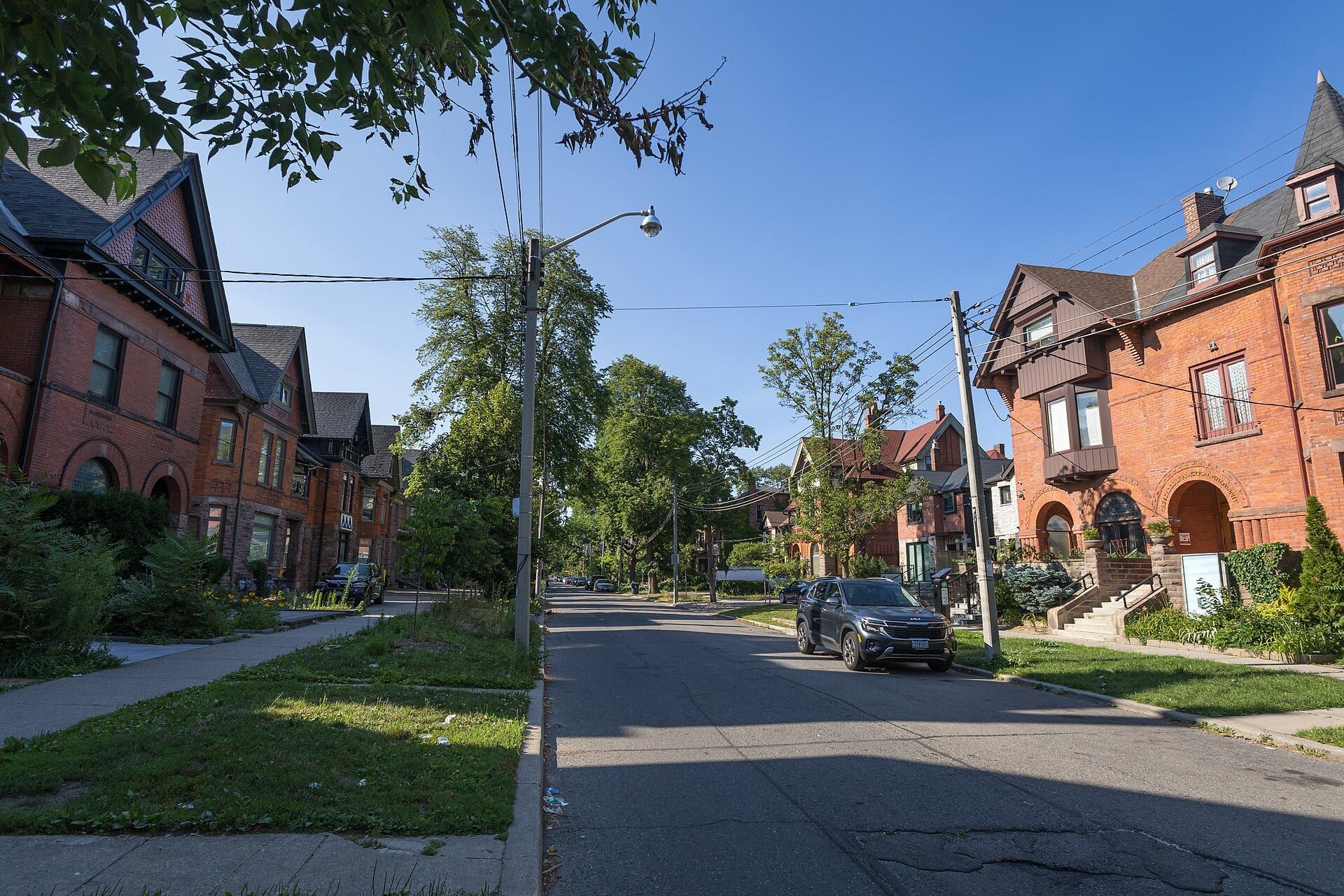 Victorian brick houses and mature trees along Madison Avenue in The Annex, Toronto.
