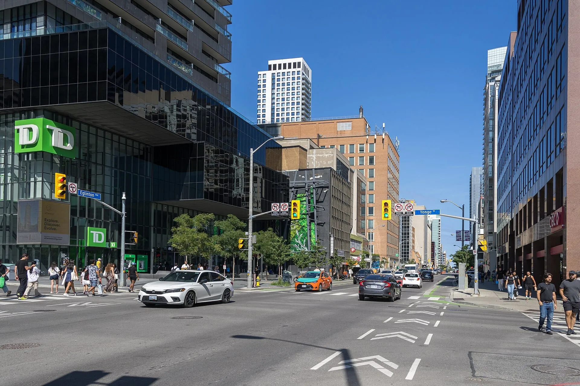 Office towers and condos at the corner of Yonge Street and Eglinton Avenue in Midtown Toronto on a sunny day.